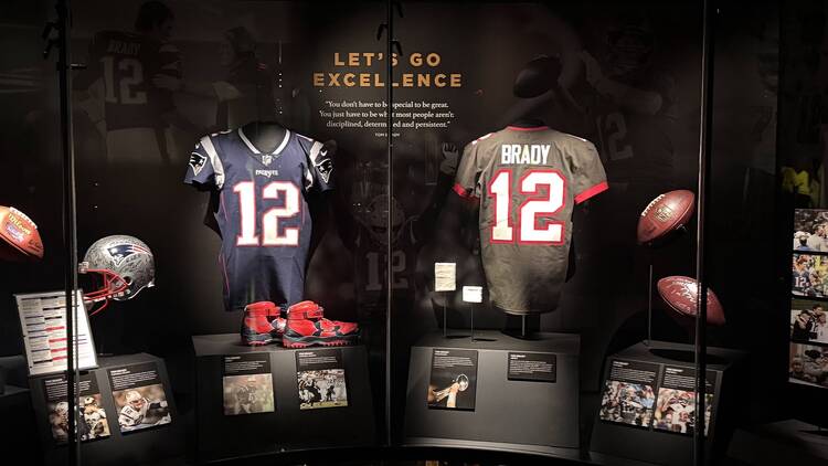 Collection of Tom Brady jerseys displayed in a collector's room